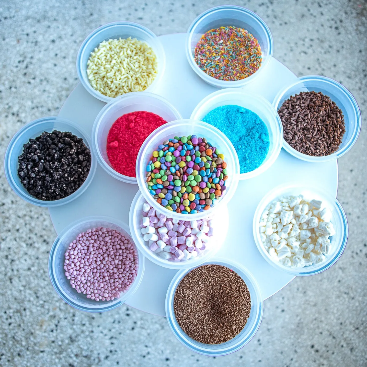 Tubs of colourful ice cream toppings and sprinkles at Manfredi